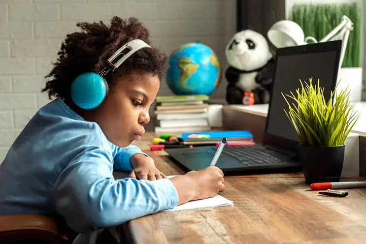 Elementary school student writing homework at home